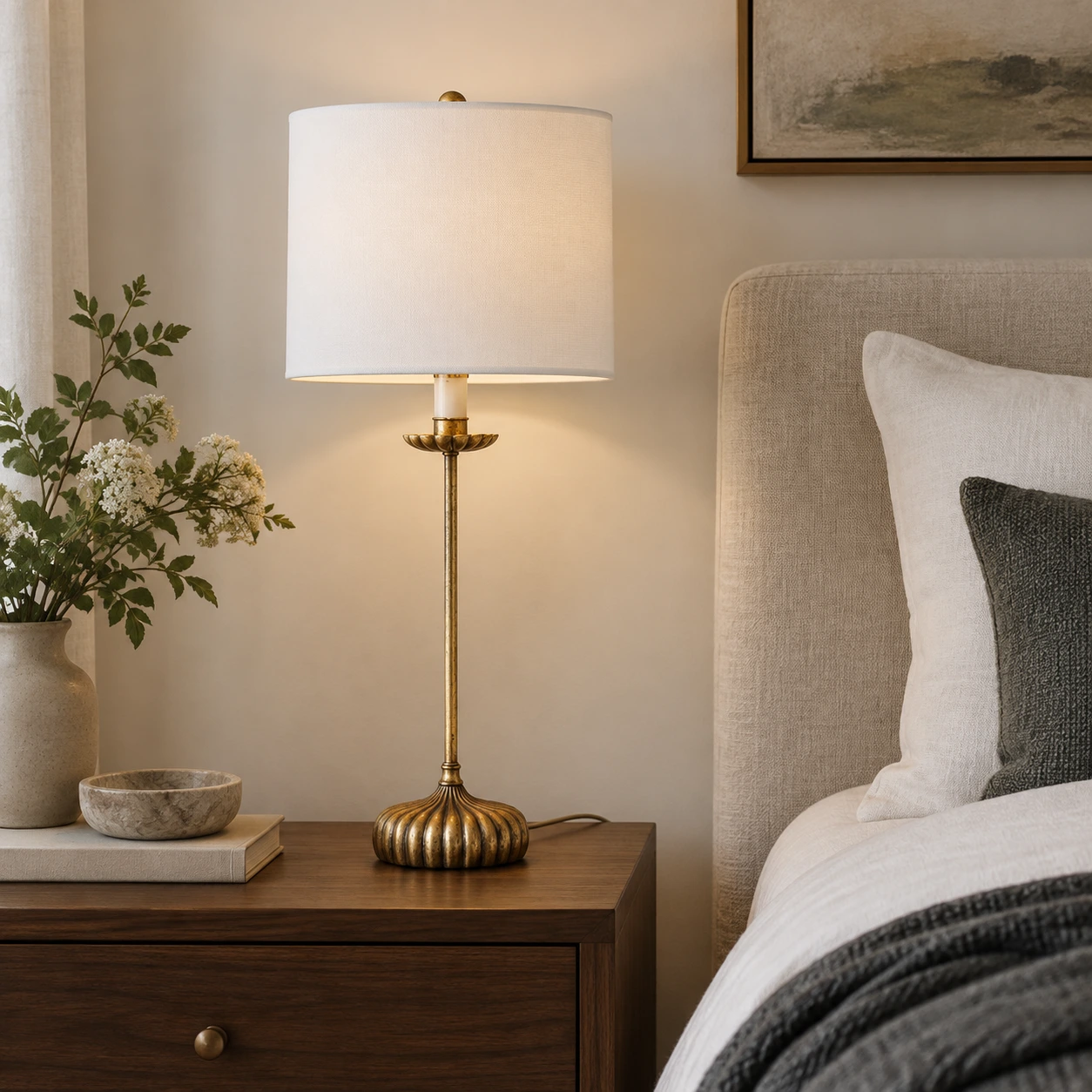 White shade table lamp beside a bed