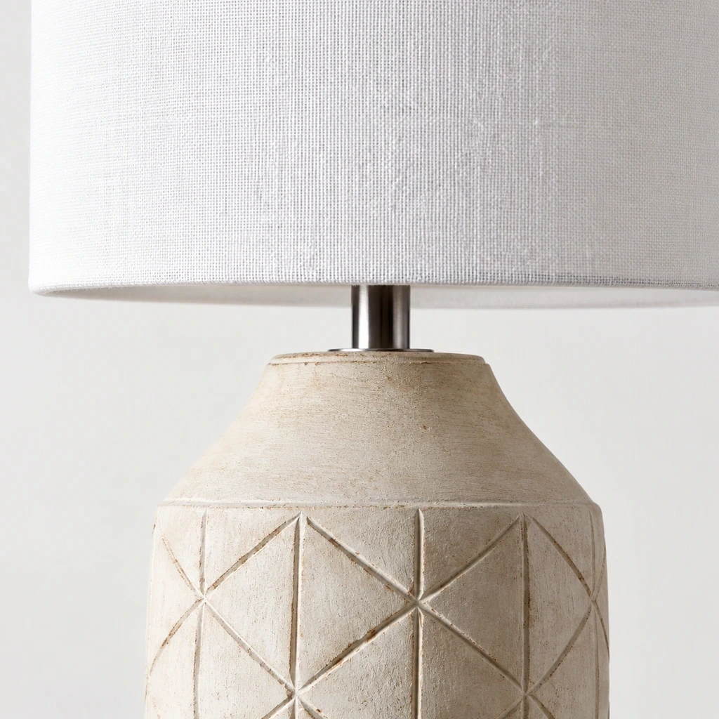 Close detail of the white fabric drum shade, turned neck and carved wood shoulder