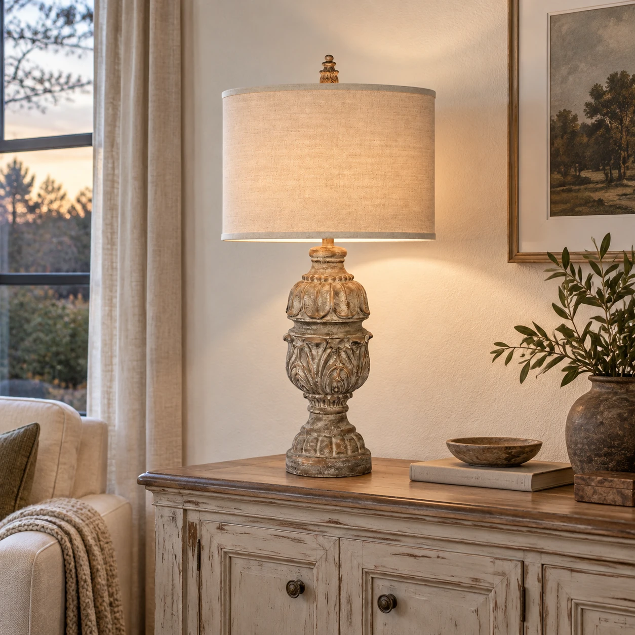 Carved wood table lamp on a living room sideboard at dusk