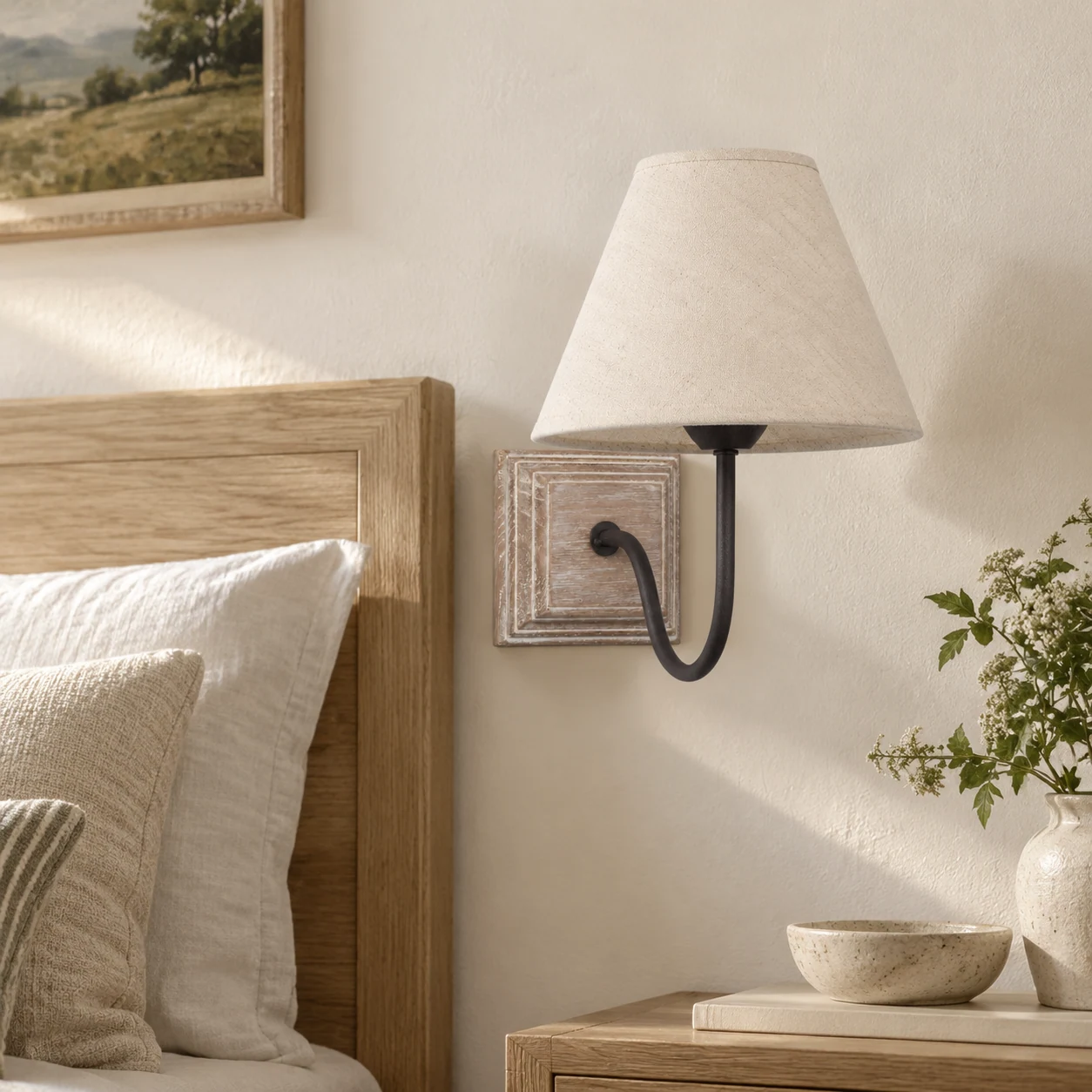 Single fabric-shade wall sconce at a bedside wall