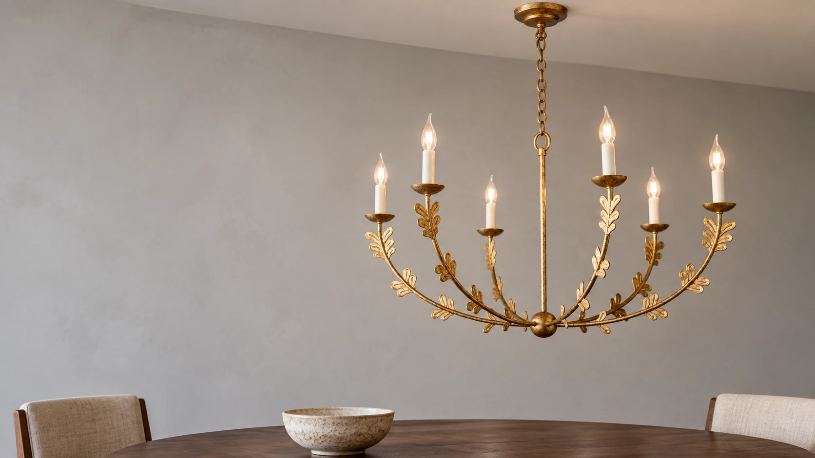 Gold leaf-detailed iron chandelier in a dining nook