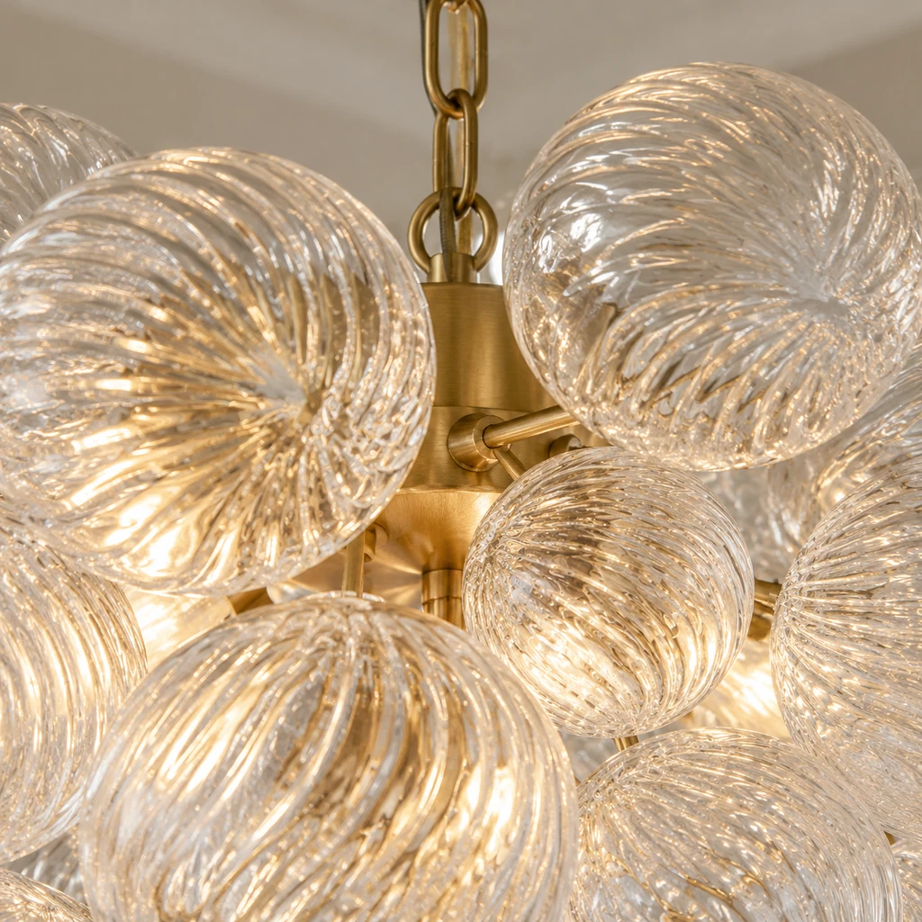 Close detail of clear glass supports joining the concealed brass frame