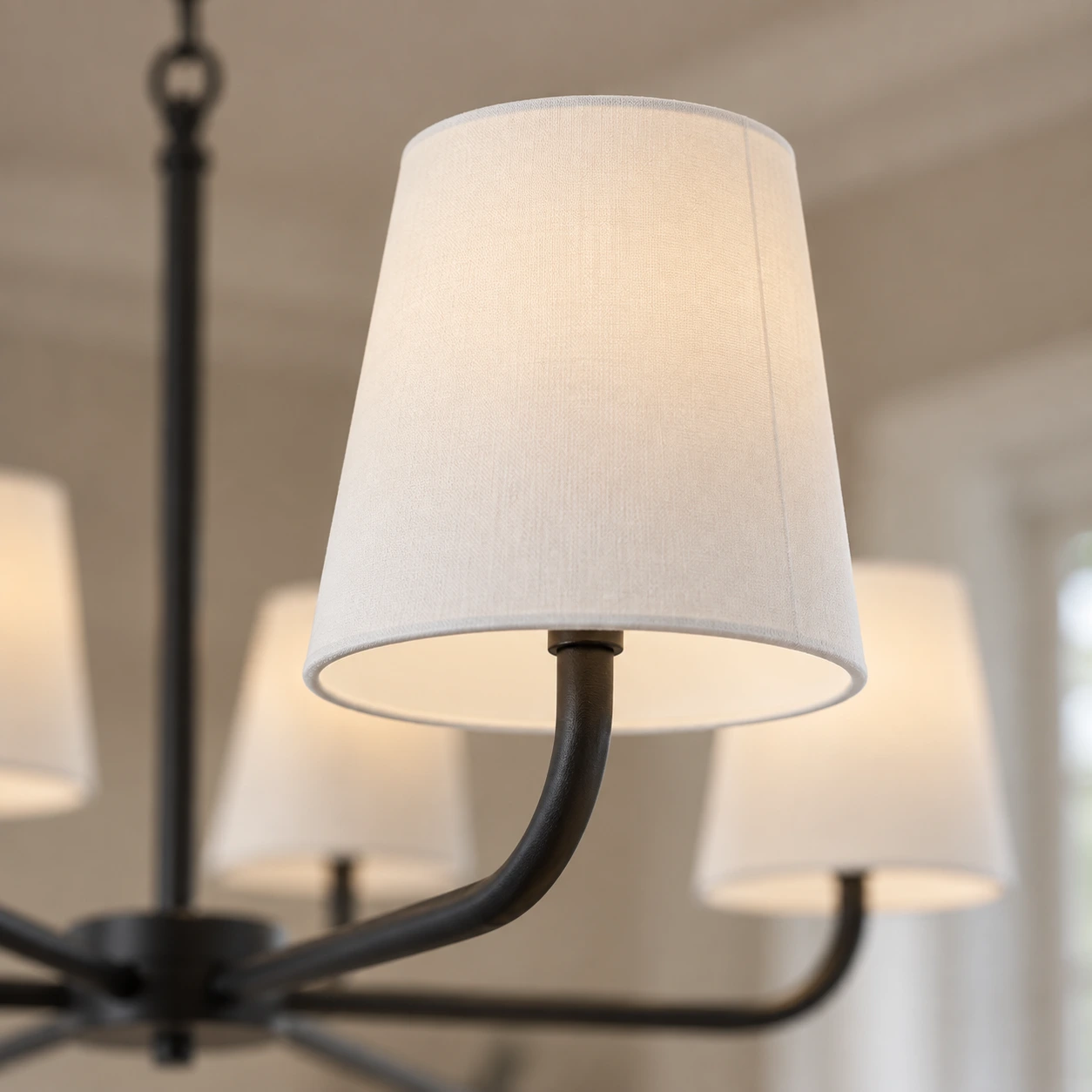Close view of white fabric shade and black iron arm