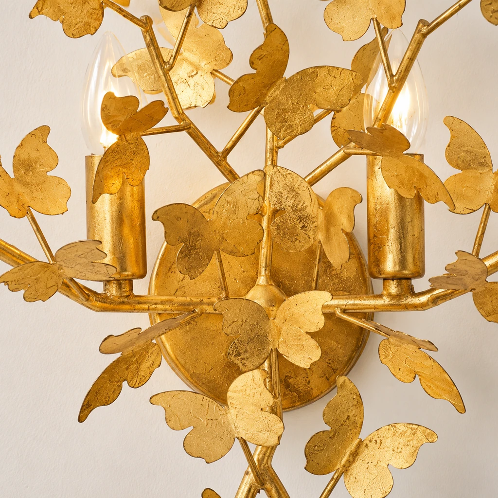 Close detail of Nora round gold wall backplate and branch connections