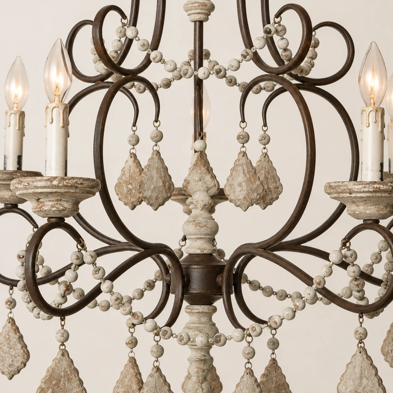 Close detail of Mara iron scroll branches and wood bead strands