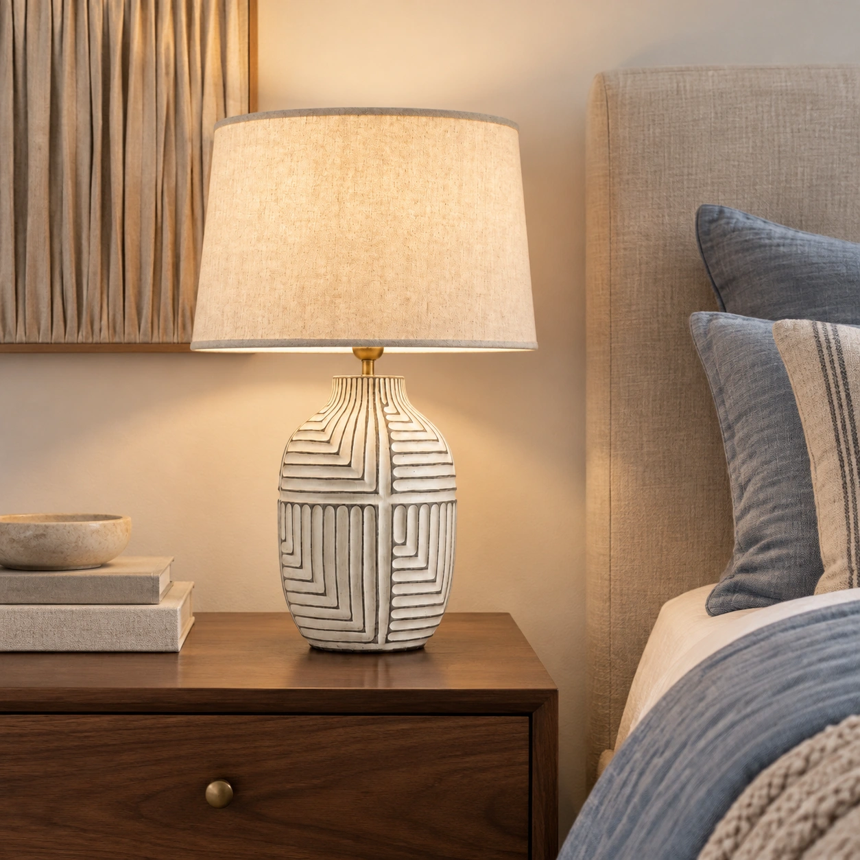 Carved wood table lamp beside a bed