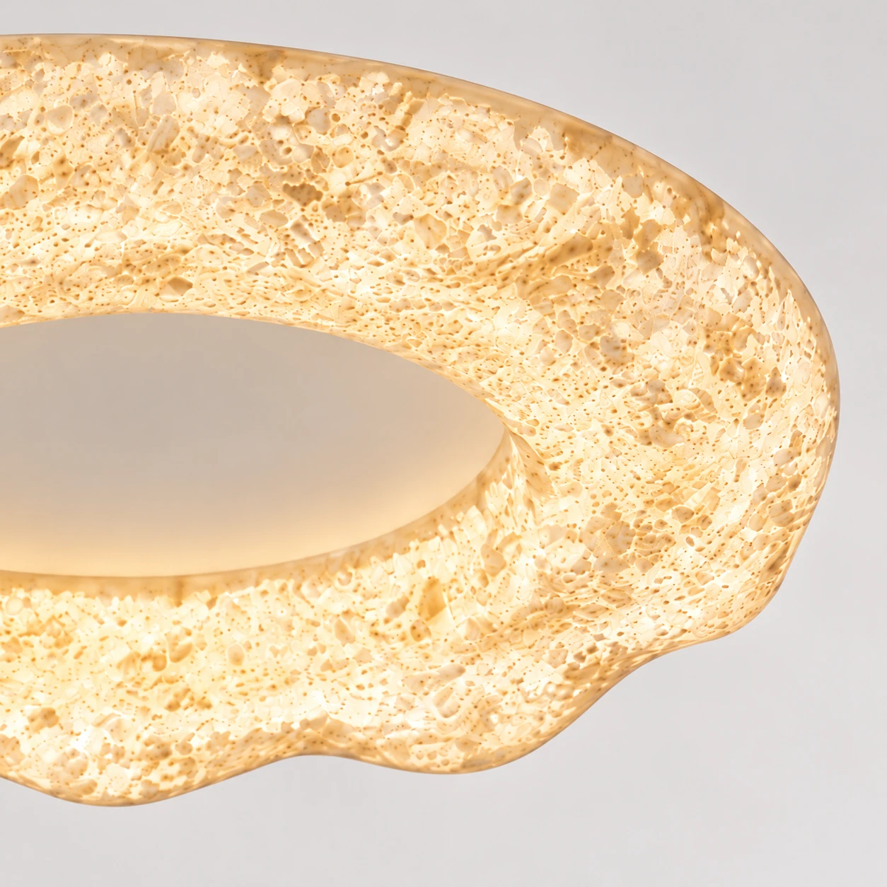 Close view of Clara's sculpted sand-white resin ring and rounded edge