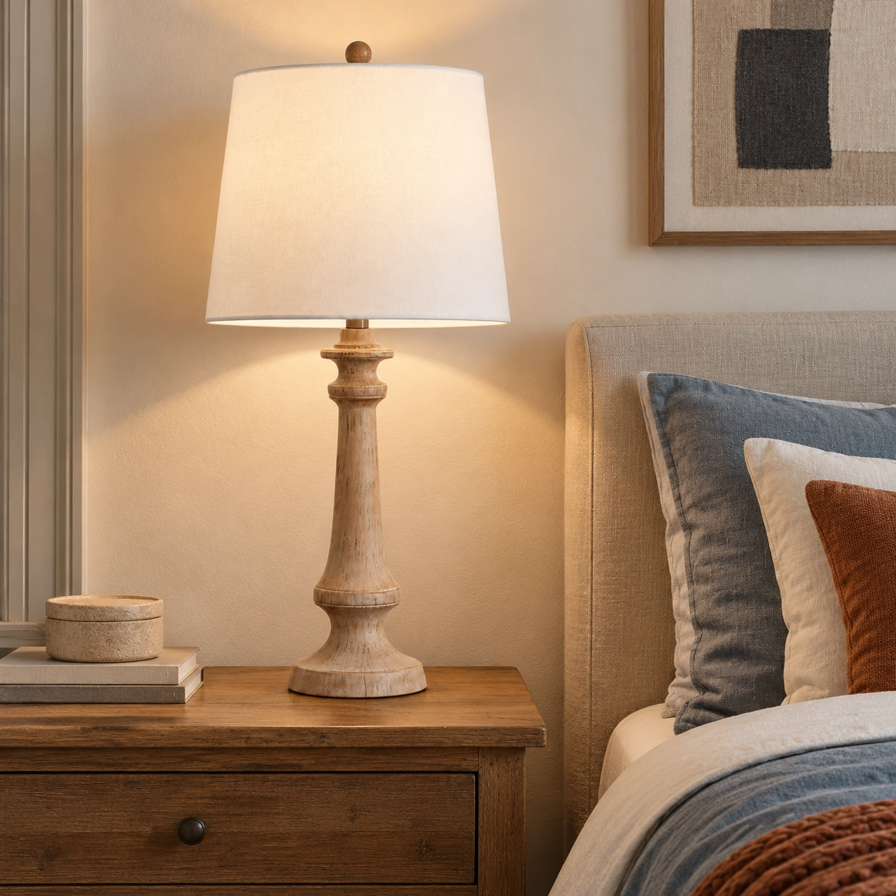 Turned wood table lamp beside a bed
