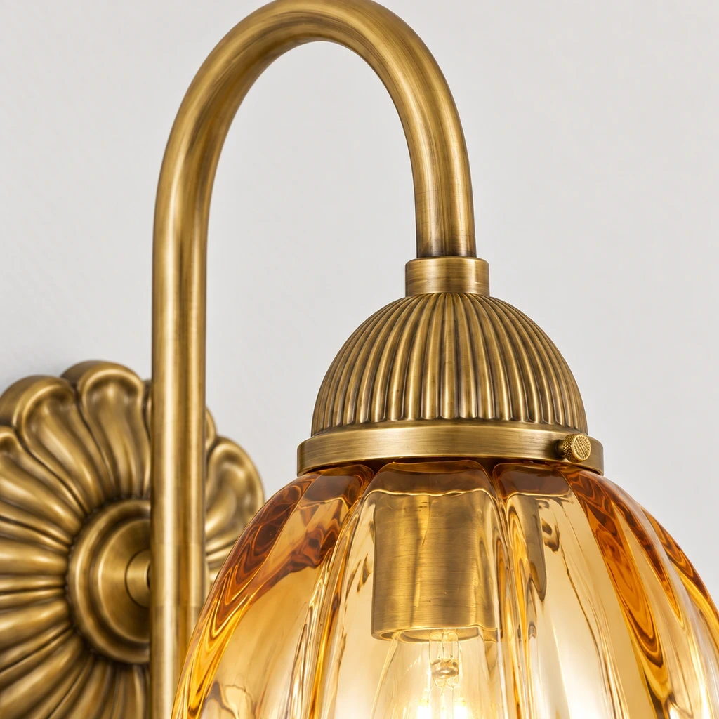 Close view of the tall curved aged-brass-toned arm