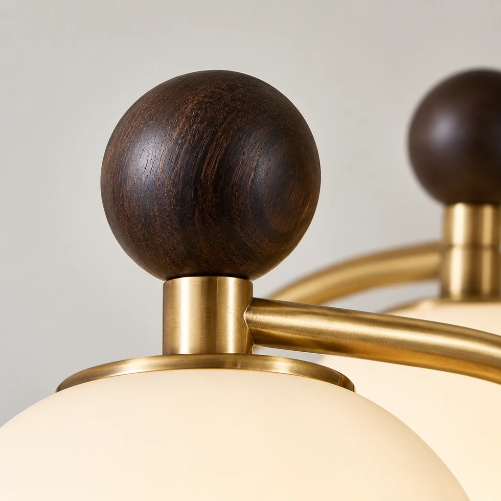Close detail of a dark wood sphere and warm-metal arm