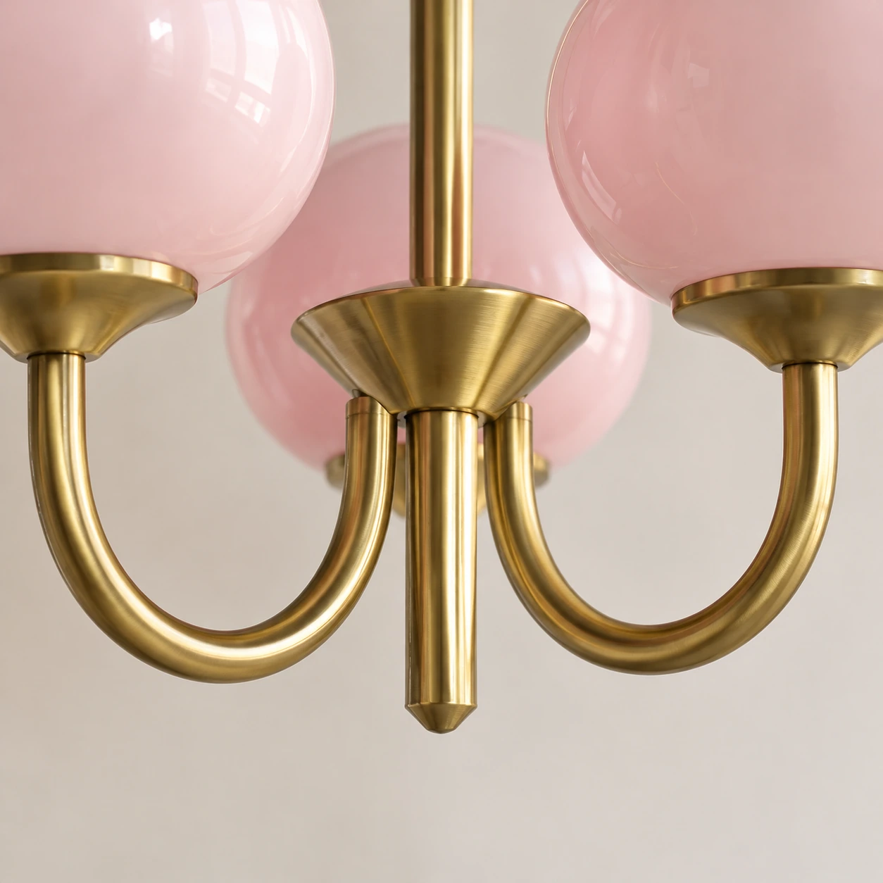 Close detail of the brass-toned iron arm and glass-shade connection