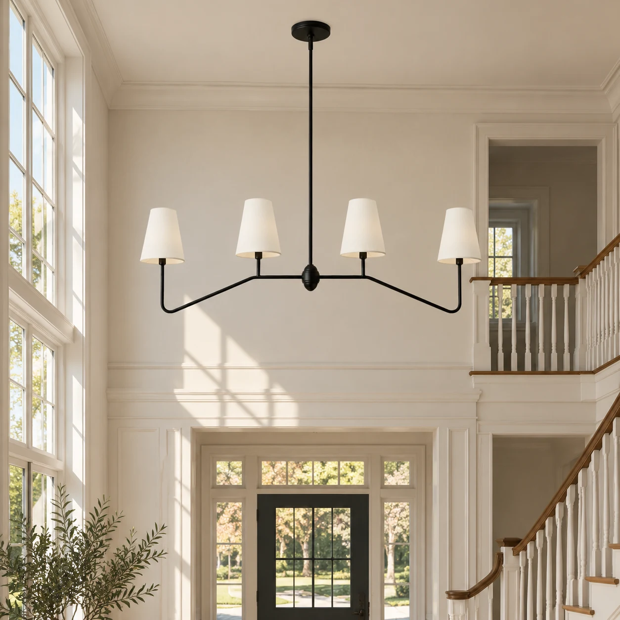 White-shade four-light iron chandelier suspended in a tall American entry hall
