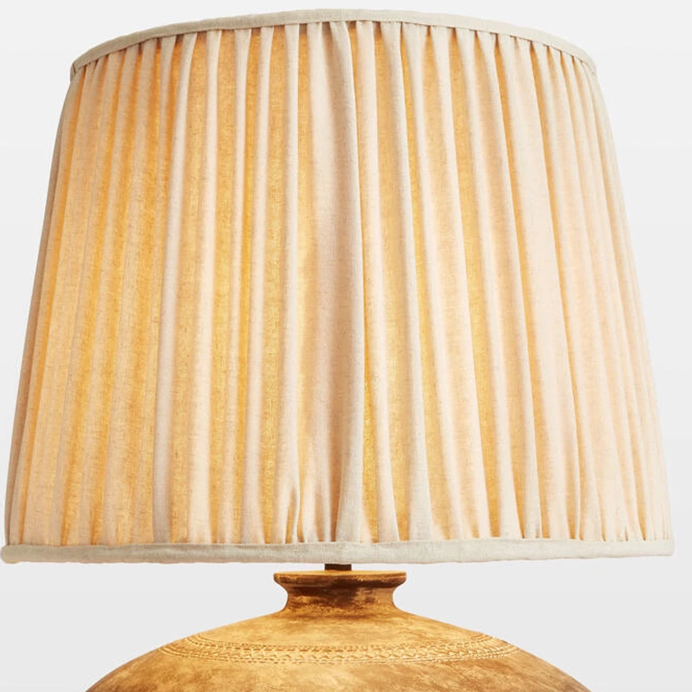 Close view of the pleated fabric shade and bound lower edge