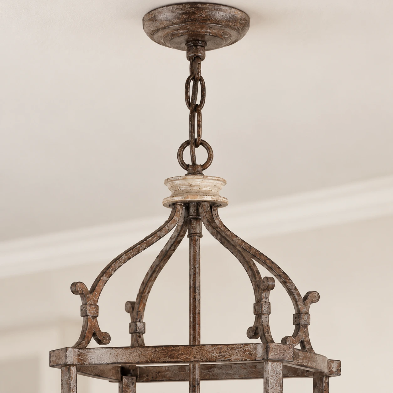 Close detail of the chain, curved iron arms and upper birdcage frame