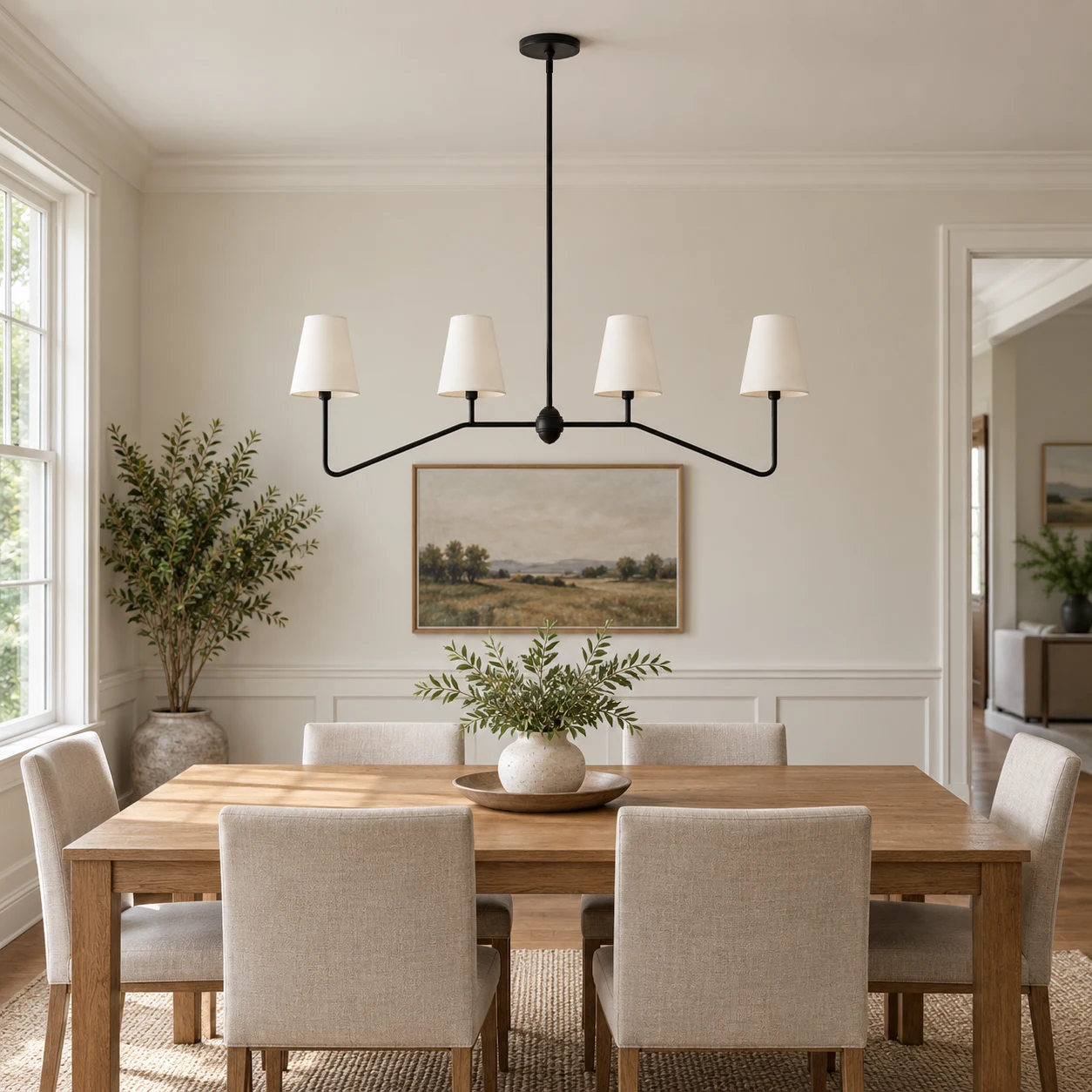 White-shade four-light iron chandelier above an oak dining table in an American home