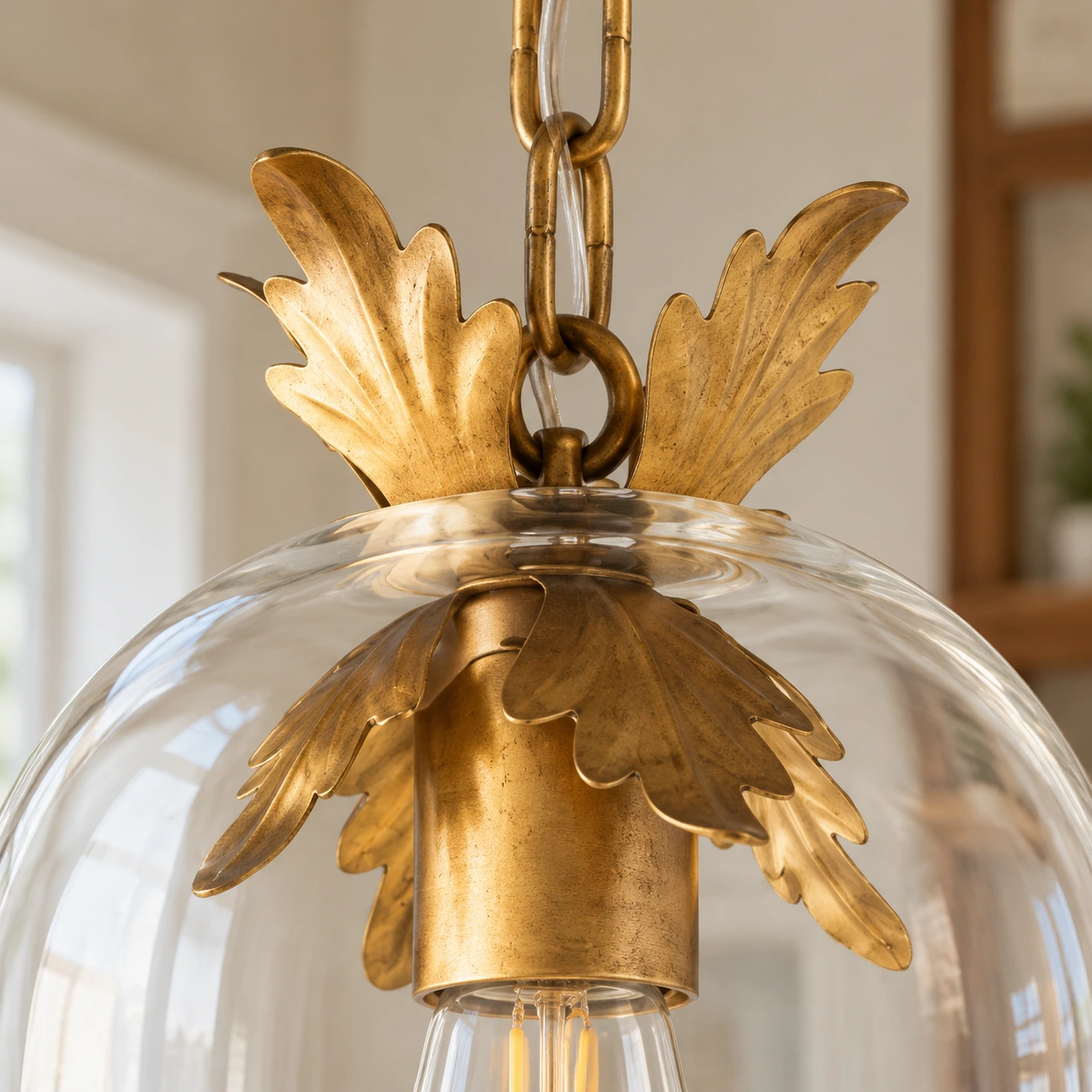 Close detail of antique gold leaf trim, clear glass rim and chain connection