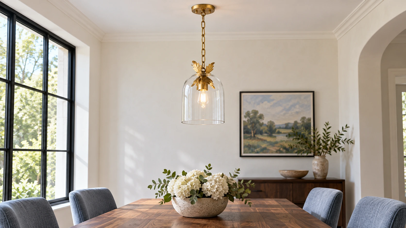Clear glass pendant with antique gold leaf trim in a dining room