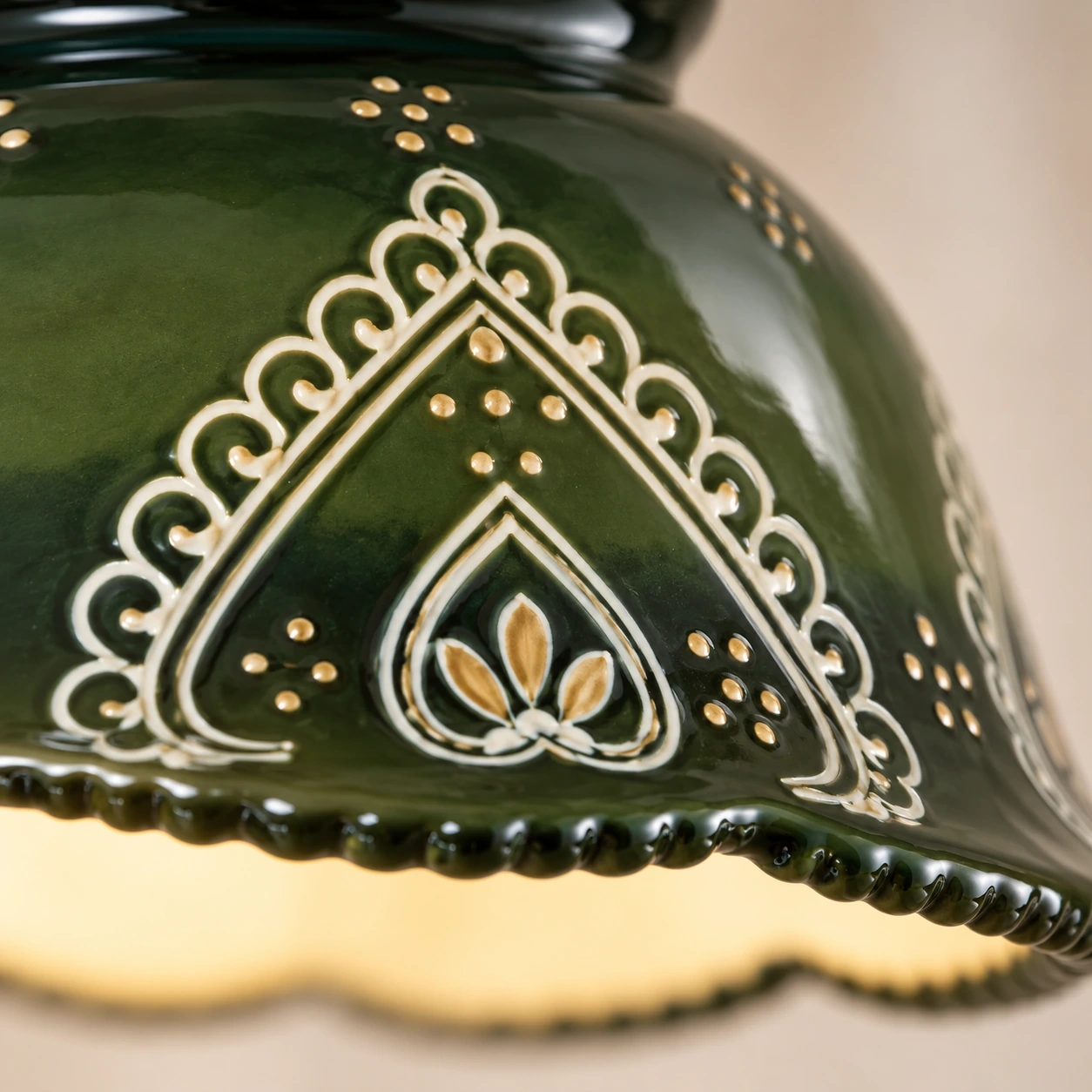 Dark green scalloped ceramic shade with raised cream and gold ornament
