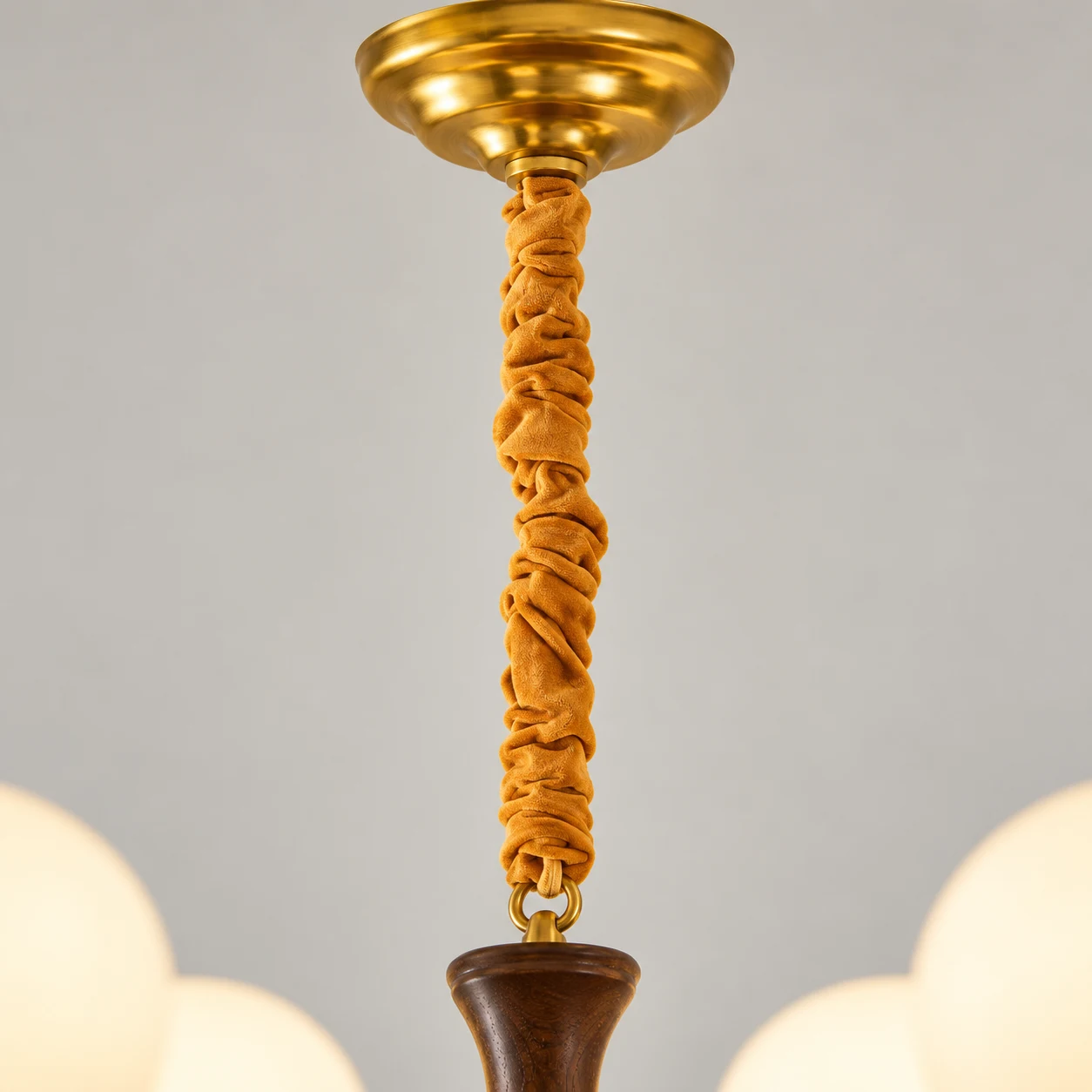 Vertical close-up of brass canopy and fabric-wrapped stem