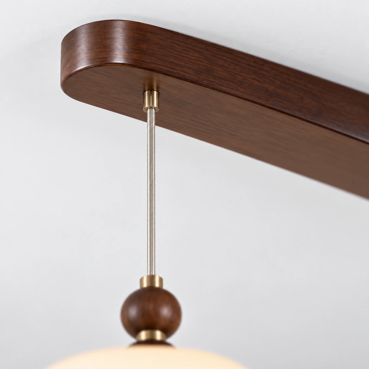 Close detail of the walnut canopy bar and cord exit